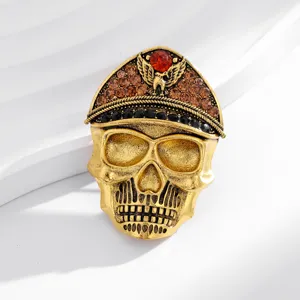 Close-up detail shot of vintage gold skull brooch with military cap, amber and black rhinestones.