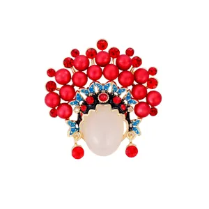 Elegante spilla con maschera d'opera cinese con perle rosse e strass scintillanti.