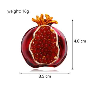 Detailed close-up of red pomegranate brooch, alloy enamel craft, exquisite accessory.