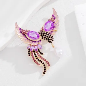 Elegante feniks vogel broche met paarse kristallen, roze geëmailleerde vleugels en parel.