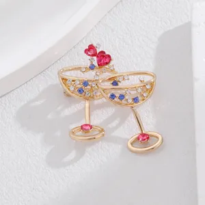 Detalle de broche de aleación dorada copa de champán brindis, pedrería brillante y corazón.