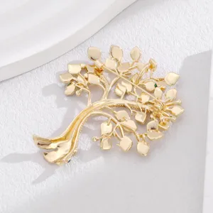 Broche arbre dore avec branches de feuilles delicates, bijou de mode elegant et minimaliste.