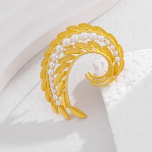 Exquisite pearl feather brooch detail shot, elegant gold leaf design for women workplace style.