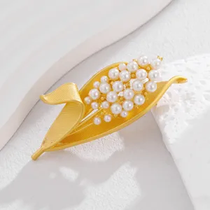 Exquisite detail shot of the golden pearl leaf brooch, showcasing delicate craftsmanship and shine.