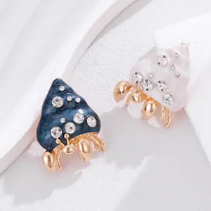 Detail view of cute alloy enamel hermit crab shell brooch with sparkling rhinestones.