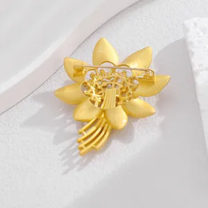 Rückseite einer goldenen Blumenbrosche mit filigraner Nadelstruktur und Metallverarbeitung.