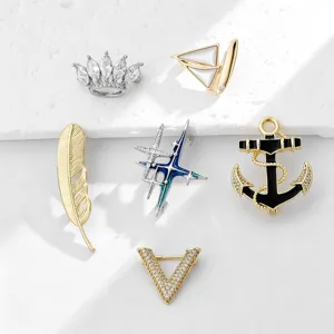 Detailed view of stylish alloy brooches featuring crown sailboat and crystal V designs.