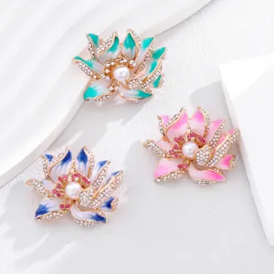 Detailed close-up of exquisite enamel lotus brooch featuring sparkling rhinestones and pearl center.
