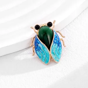 Exquisite close-up of a traditional Chinese cicada brooch with green jade-like body and blue enamel wings.