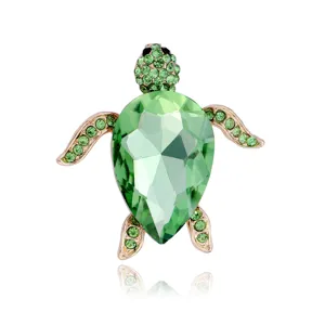 Close-up detail of the elegant green crystal turtle brooch with sparkling rhinestone accents.