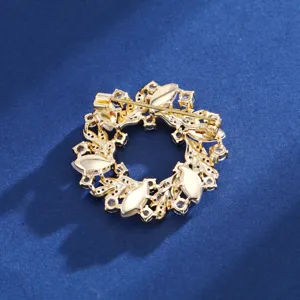 Détail du dos de la broche fleur plaquée or avec fermoir épingle et strass étincelants.