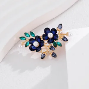 Gedetailleerde close-up van een prachtige kristallen bloemenbroche met blauwe strass en parels.