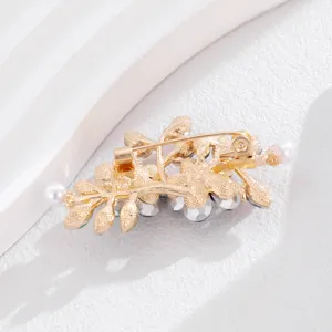 Achterkant detail van elegante gouden bloem strass broche pin met fijne afwerking.