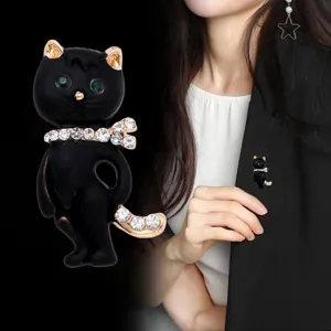 Elegant black cat brooch featuring sparkling green crystal eyes and rhinestone details for women.