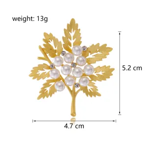 Detailansicht der goldenen Ahornblatt-Brosche mit glänzenden Perlen und funkelnden Kristallen.