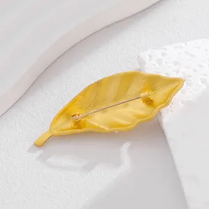 Detailansicht der eleganten goldenen Blattbrosche mit sicherem Nadelverschluss auf der Rückseite.