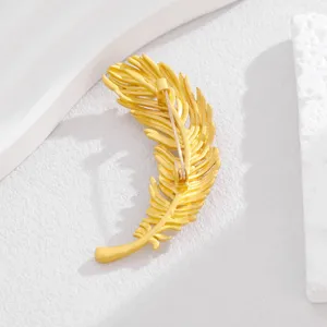 Nahaufnahme der goldenen Feder Brosche, elegantes Metall Design für vielseitigen Stil.