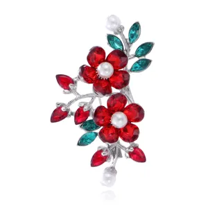 Prachtige kristallen strass bloem broche met sprankelende rode en groene stenen en parels.