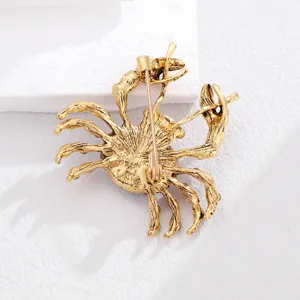 Nahaufnahme der goldenen Krebs Brosche Rückseite mit Sicherheitsnadel auf weißem Untergrund.