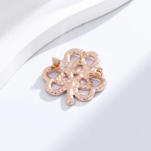 Gros plan détail du dos d'une broche trèfle en or rose, bijou de mode élégant et chic.
