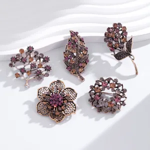 Vintage rhinestone brooch set detail, featuring intricate botanical designs like leaves and flowers.