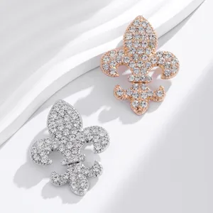Detailed view of exquisite fleur-de-lis rhinestone brooches in silver and rose gold finishes.