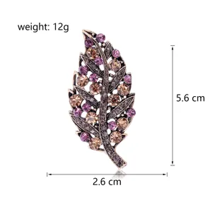 Detailed view of vintage leaf brooch decorated with purple and champagne rhinestones.