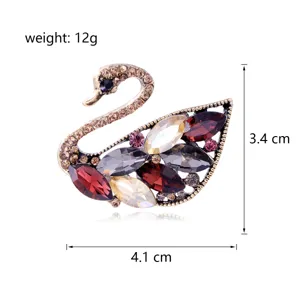 Close-up detail shot of a sparkling rhinestone swan brooch featuring colorful crystal stones.