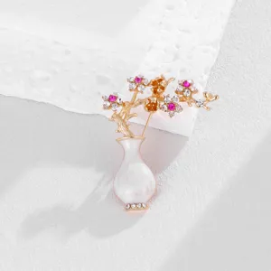 Vintage rhinestone plum blossom vase brooch, elegant gold metal flower pin accessory.