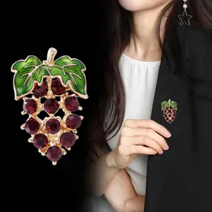 Exquisite grape brooch featuring sparkling red crystals and green enamel leaves, perfect for outfits.