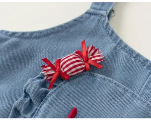 Vue détaillée de salopette en denim pour fille avec jolie décoration de bonbon à carreaux.