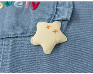 Détail de vêtement en denim pour enfants avec étoile brodée mignonne et lettrage mignon.