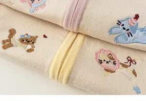 Close-up detail of cute cat embroidered knit cardigan for girls with striped trim texture.