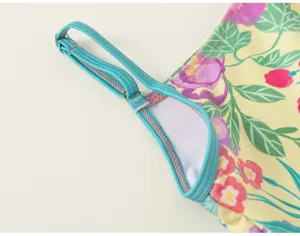 Girls one-piece swimsuit strap detail, vibrant floral print, summer swimwear style.