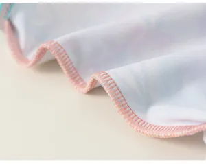 Close-up of children swimwear fabric and pink overlock stitching detail showing fine workmanship.