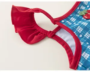 Girls one-piece swimsuit detail view, showing red ruffle straps and cute cherry decor.