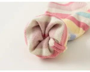 Close-up detail of colorful striped children knitted sweater cuff showing soft texture.
