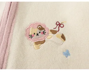 Cute cat embroidery detail on soft knit cardigan for baby girls, cozy autumn apparel close-up.