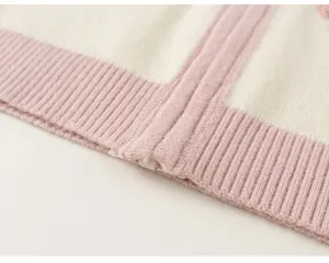 Detailed view of kids knit cardigan with pink and white stripes and ribbed hem texture.