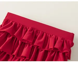 Detailed shot of vibrant red tiered ruffles on children's swimsuit, showcasing the delicate pleats and texture.