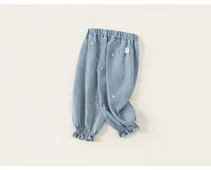 Pantaloni di jeans per neonati dettaglio, tessuto azzurro, ricamo fiori e fragole carino.