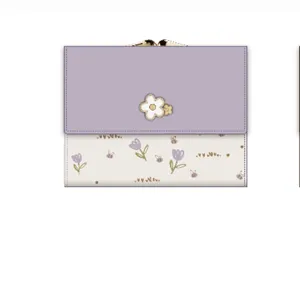 Détail du portefeuille à fleurs lavande à trois volets avec fermoir en métal et décor floral
