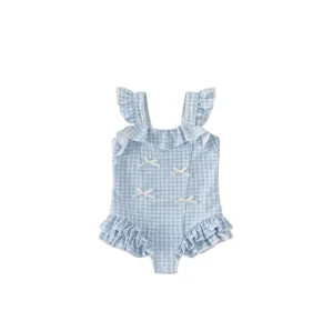 Girls blue check one-piece swimsuit detail with ruffles and cute bow accents for summer.