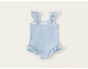 Detailed view of girls blue white checkered one piece swimsuit with ruffles straps and leg trims.