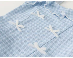 Blue and white plaid kids one-piece swimsuit detail with cute white bows and ruffles for summer.