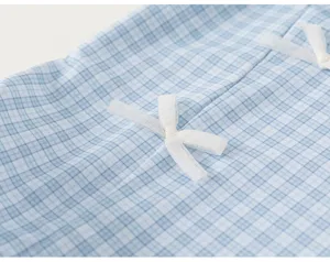 Blue and white checkered kids swimsuit fabric detail featuring delicate white mesh bow.