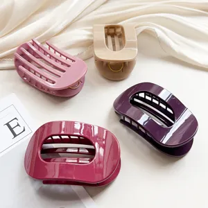 Detail shot of multi-color oval hair claw clips, minimalist resin shark clips close-up.