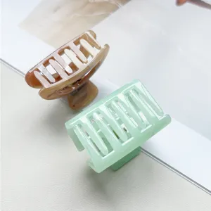 Vista dettagliata di eleganti mollette per capelli marmorizzate e verde menta, design minimal.