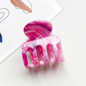 Nahaufnahme einer kleinen rosa Marmor-Haarkralle mit 4 Zähnen für stilvolle Hochsteckfrisuren.