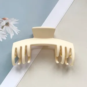 Nahaufnahme eines minimalistischen, matten beigen Haargreifers, ideal für sicheren, starken Halt.